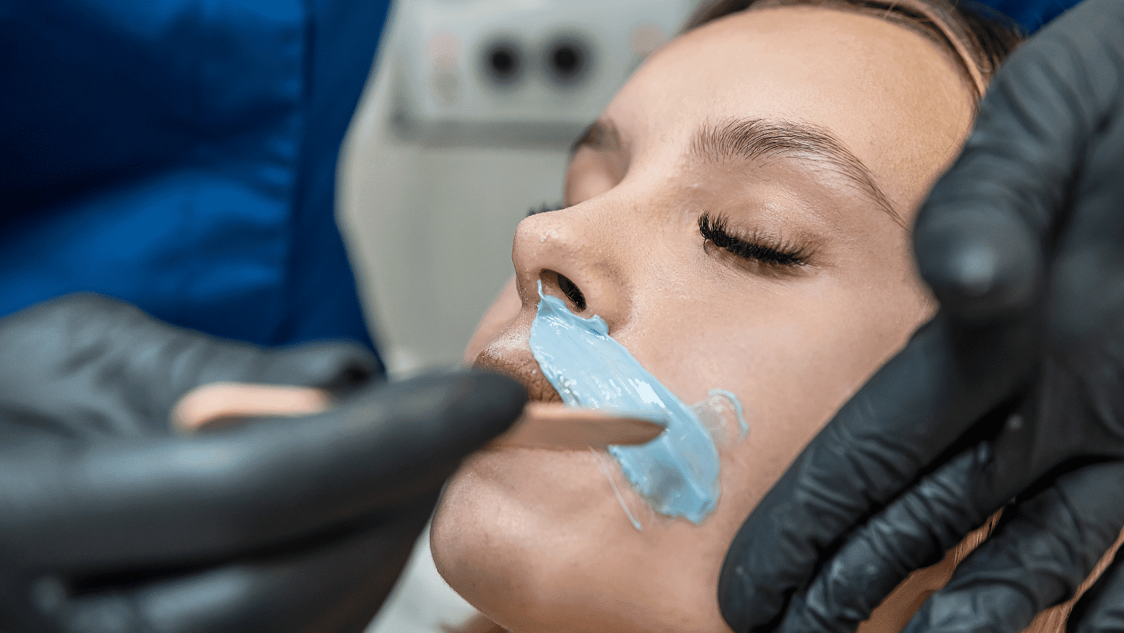 Woman receiving dental treatment with a numbing gel application.