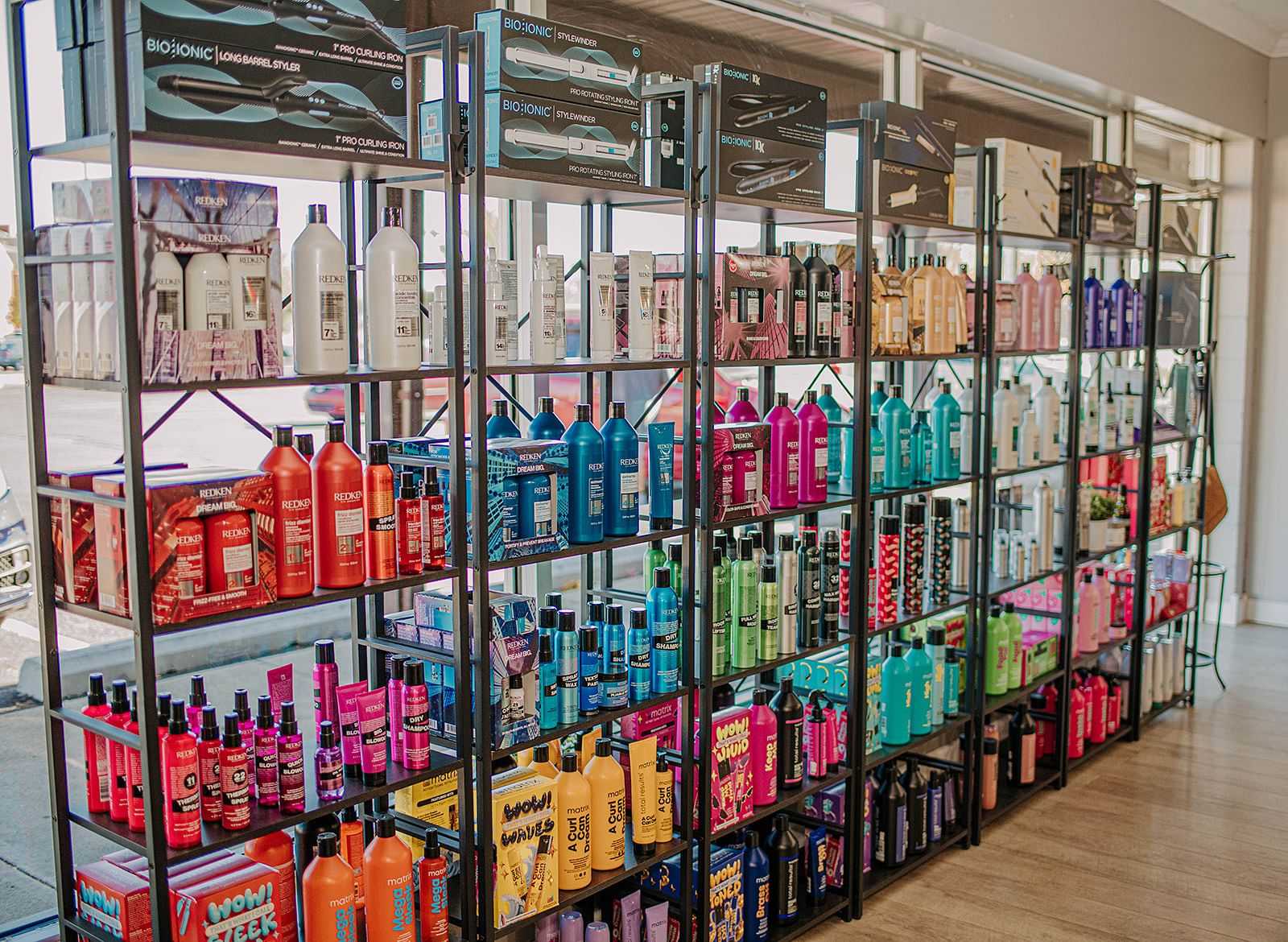 Shelves stocked with various colorful hair care products inside a store.